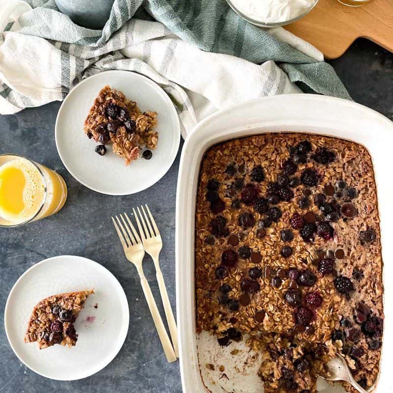 baked oatmeal with berries in casserole dish and on plates