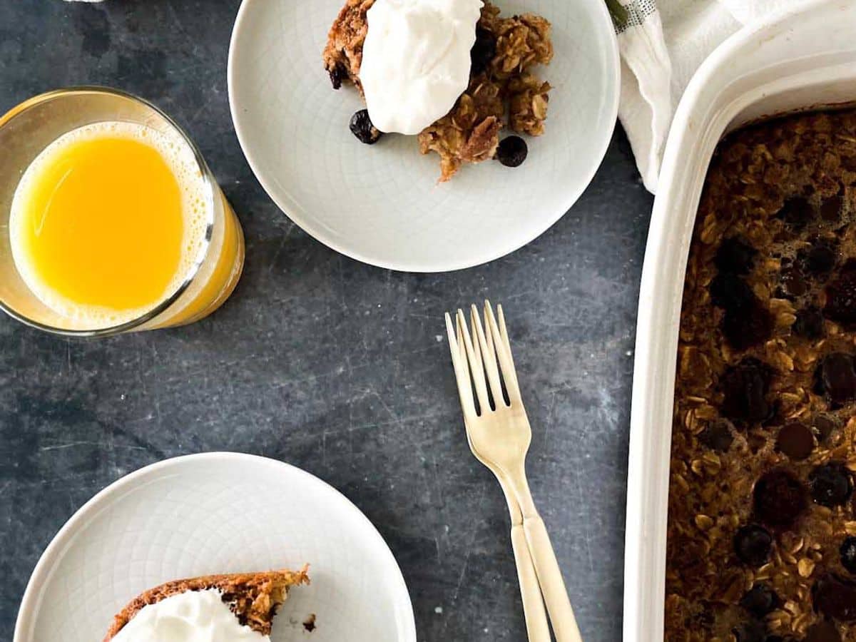 baked berry oatmeal on plate topped with whipped cream