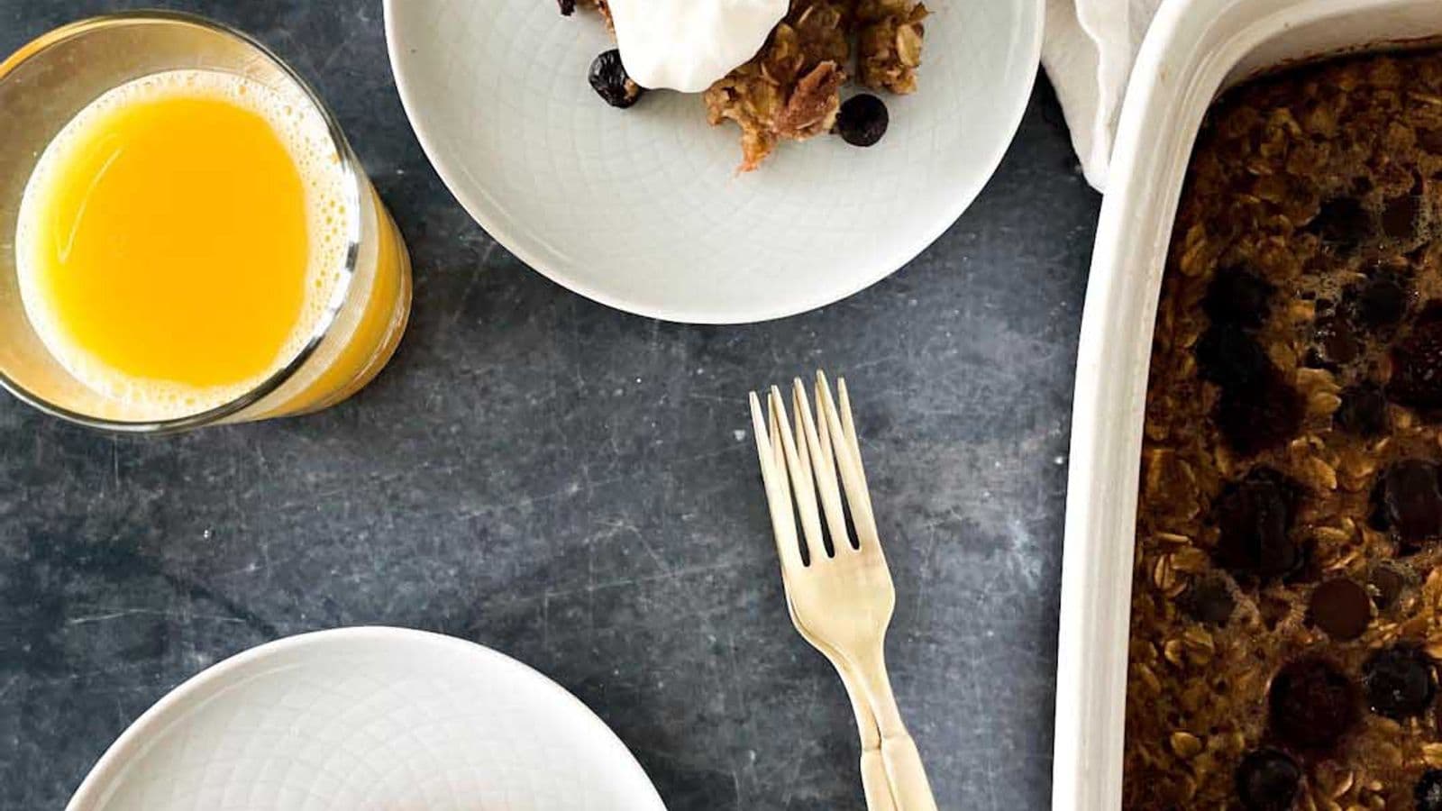 baked berry oatmeal on plate topped with whipped cream