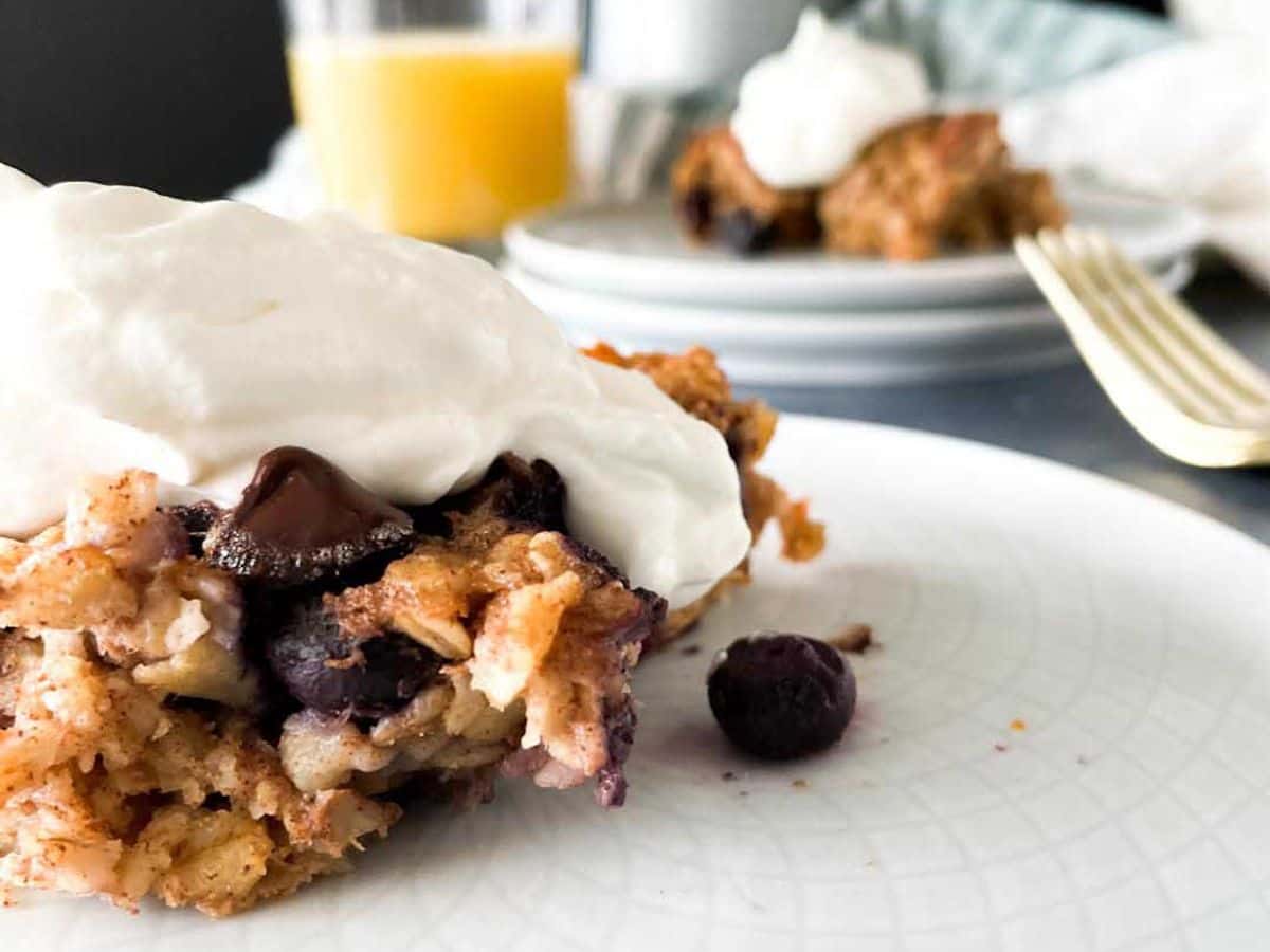 plate of baked oatmeal with berries topped with whipped cream