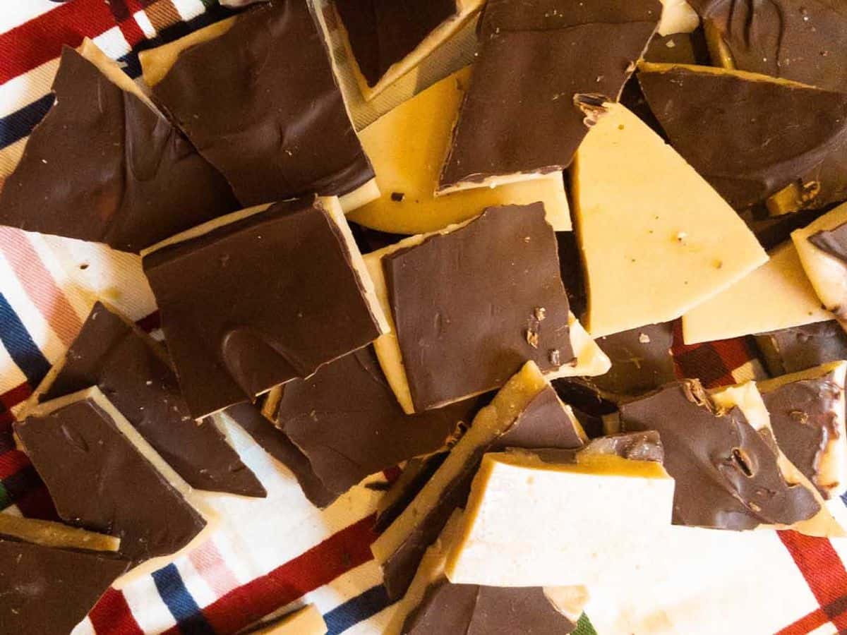 many pieces of buttercrunch lying on a dish towel on the counter