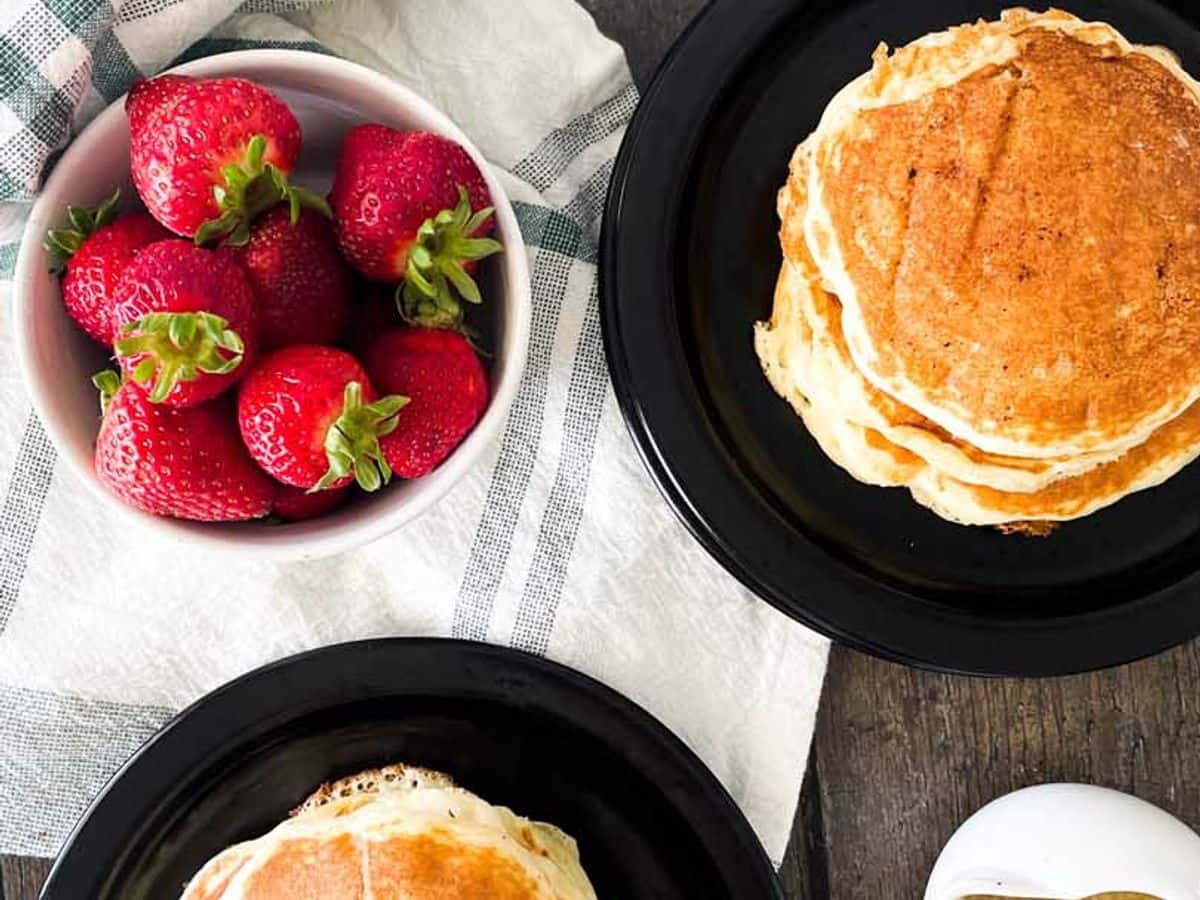 two plates with stacks of buttermilk pancakes from overhead