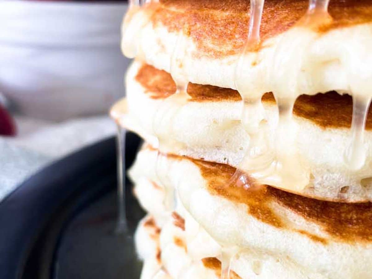 stack of buttermilk pancakes with syrup dripping down
