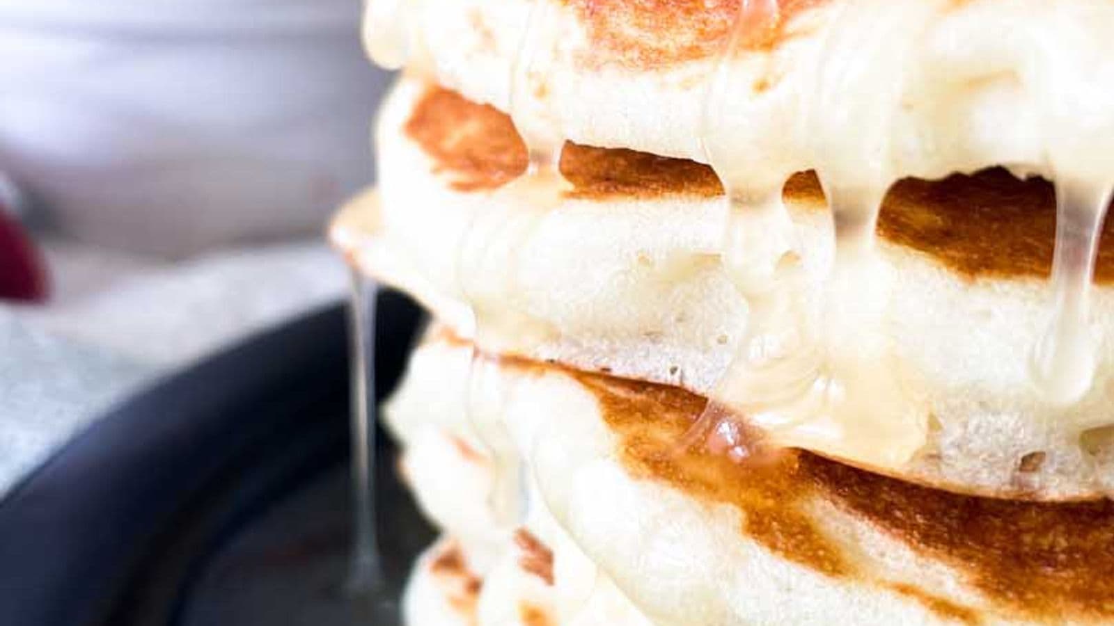 stack of buttermilk pancakes with syrup dripping down