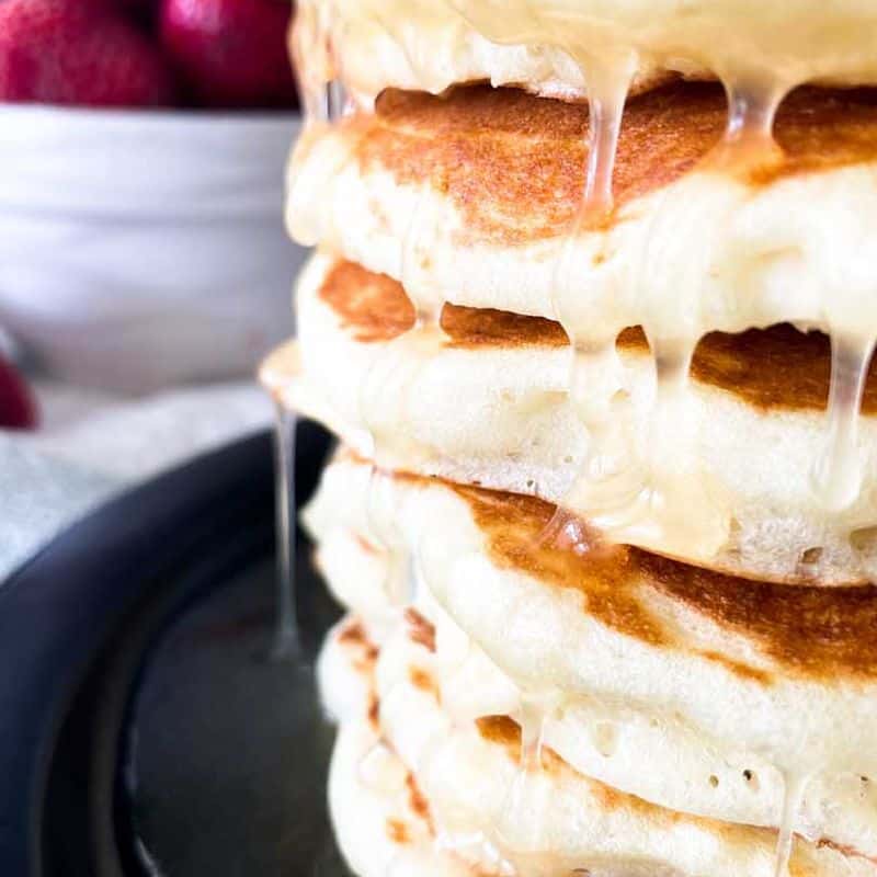 stack of buttermilk pancakes with syrup dripping down