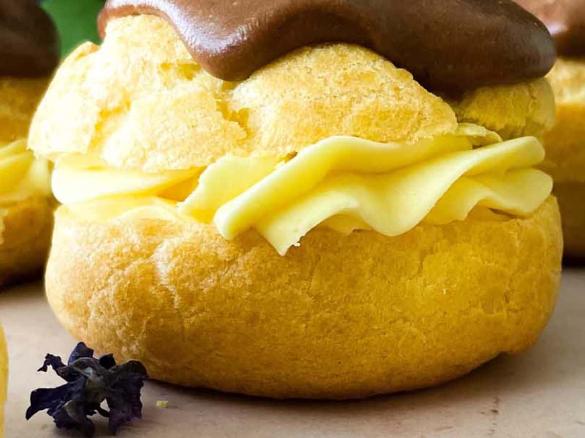 closeup of chocolate eclair cream puff from the side