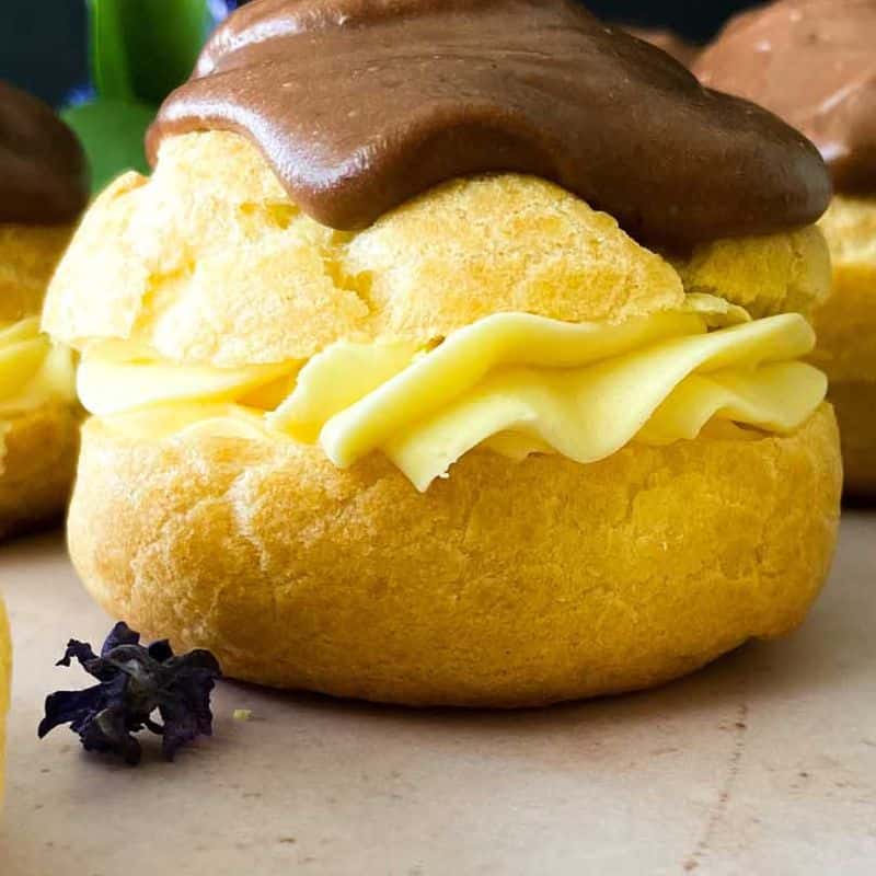 closeup of chocolate eclair cream puff from the side