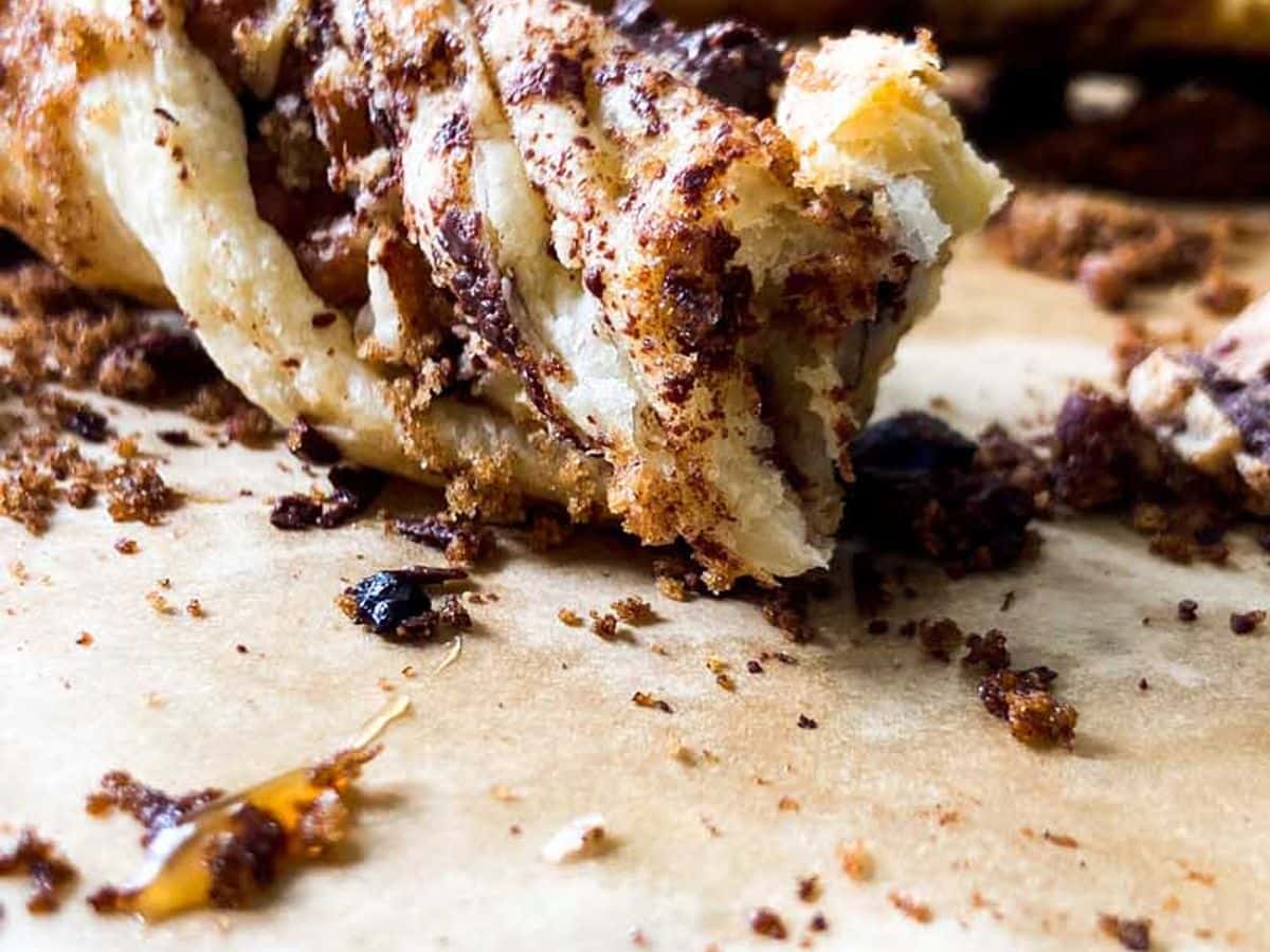 chocolate pecan twists on a counter with a bite taken out of one