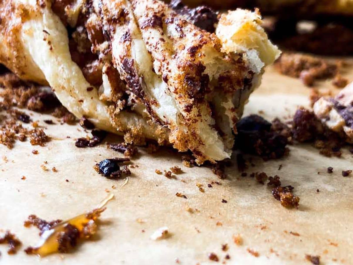 chocolate pecan twists on a counter with a bite taken out of one
