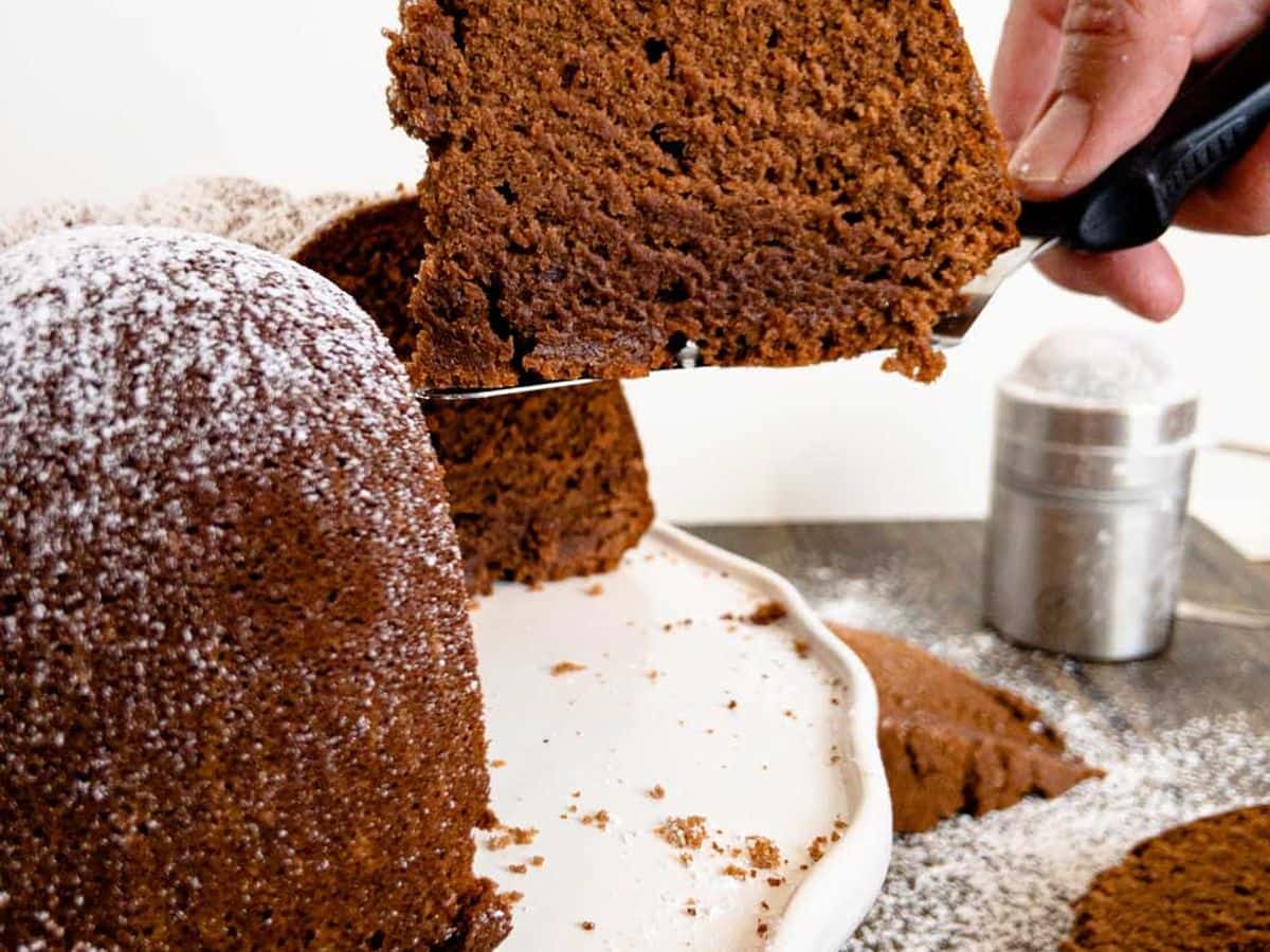 chocolate pound cake slice cut and being lifted out of the cake showing the inside of the cake
