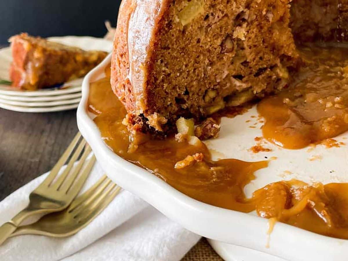 partially cut cinammon apple cake on cake stand