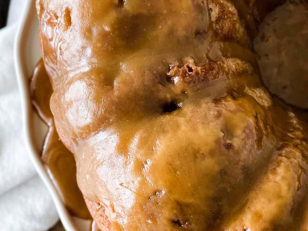 overhead view of cinnamon apple cake with caramel glaze on cake stand
