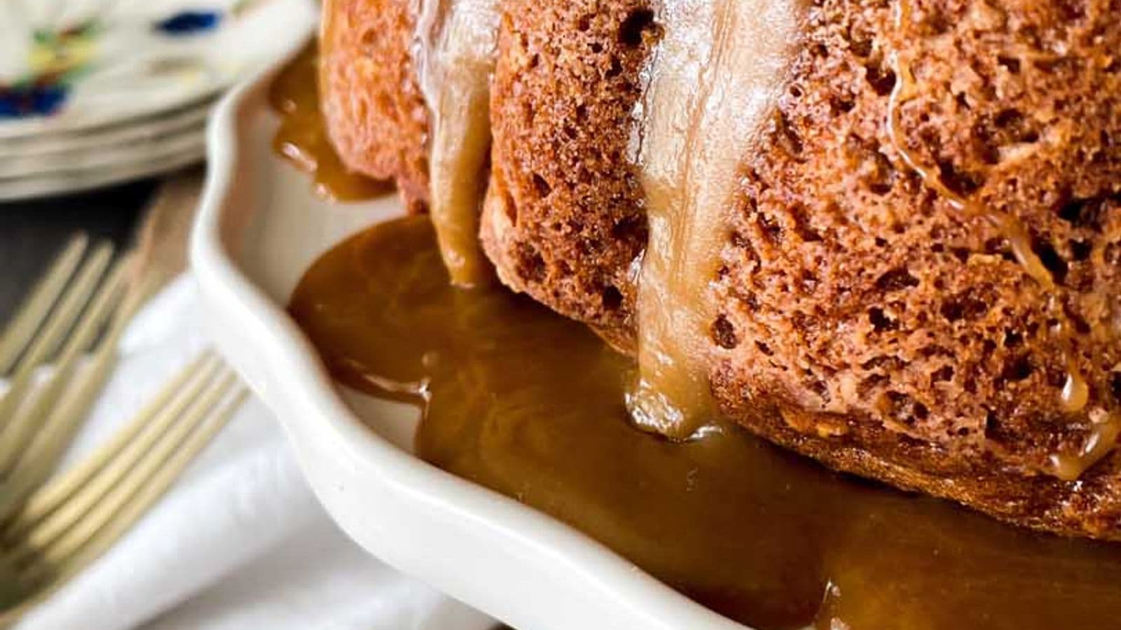 side view of cinammon apple cake on cake stand with caramel glaze