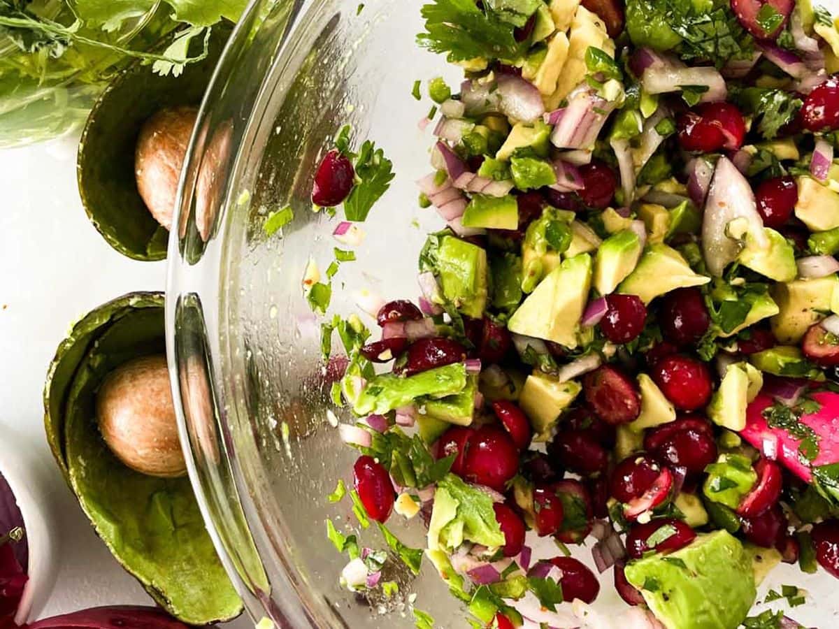 cranberry avocado salsa from overhead being mixed in mixing bowl