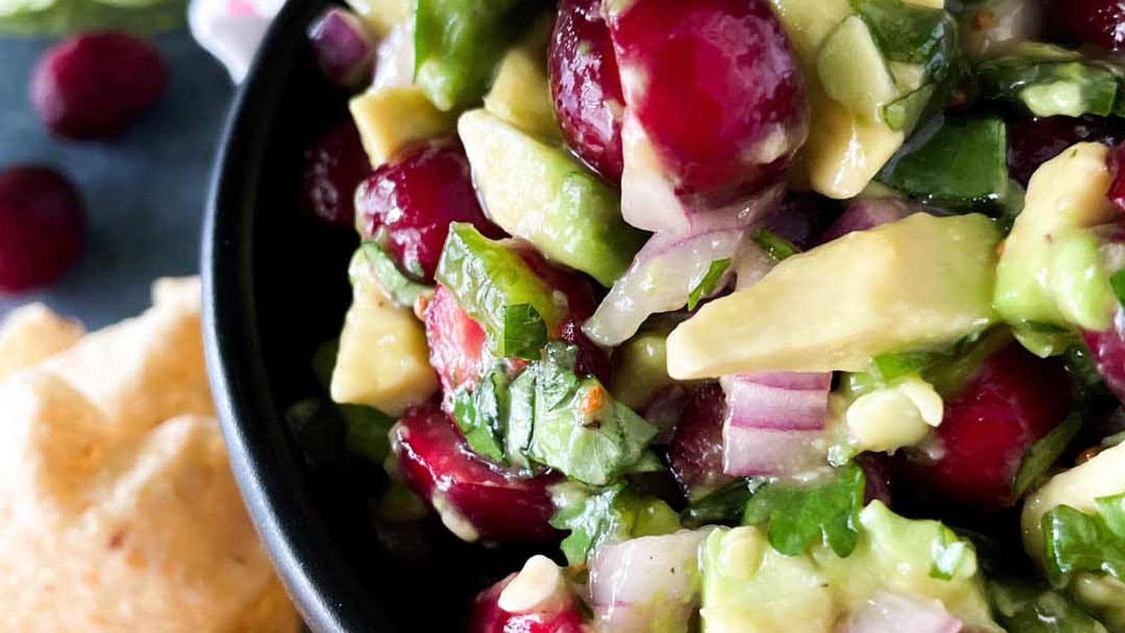 cranberry avocado salsa served in bowl with chips on the side