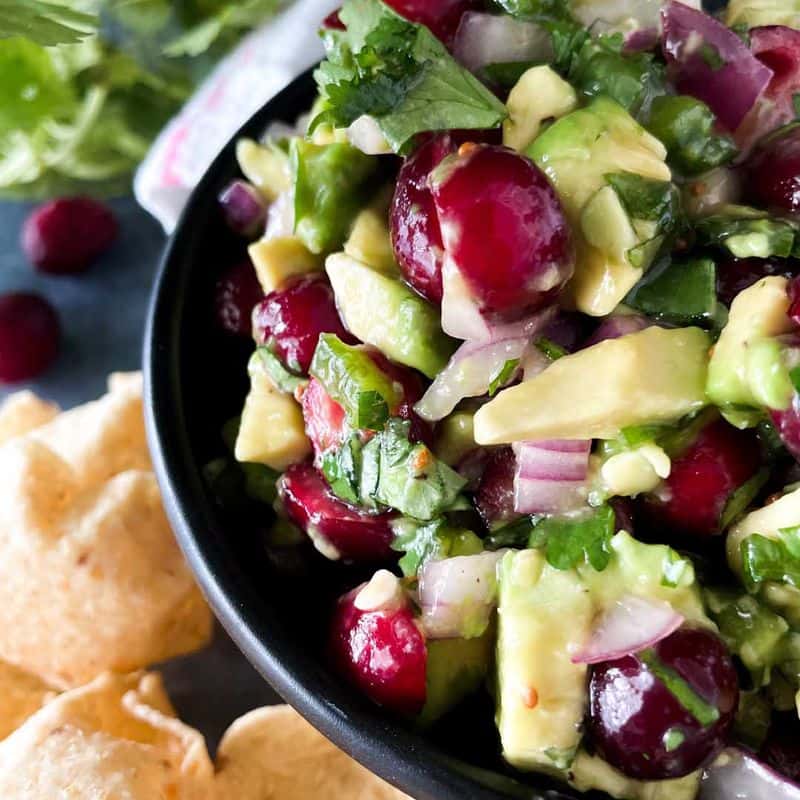cranberry avocado salsa served in bowl with chips on the side