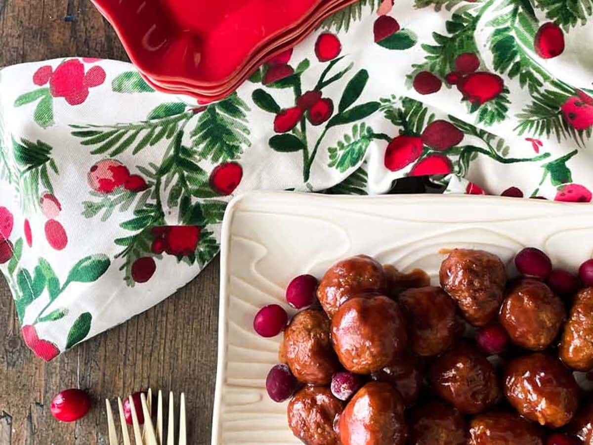 meatballs in cranberry sauce on platter and on appetizer plate with toothpicks