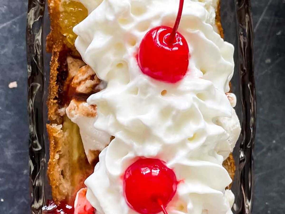 overhead view of deep fried banana split with ice cream, whipped cream, and cherries