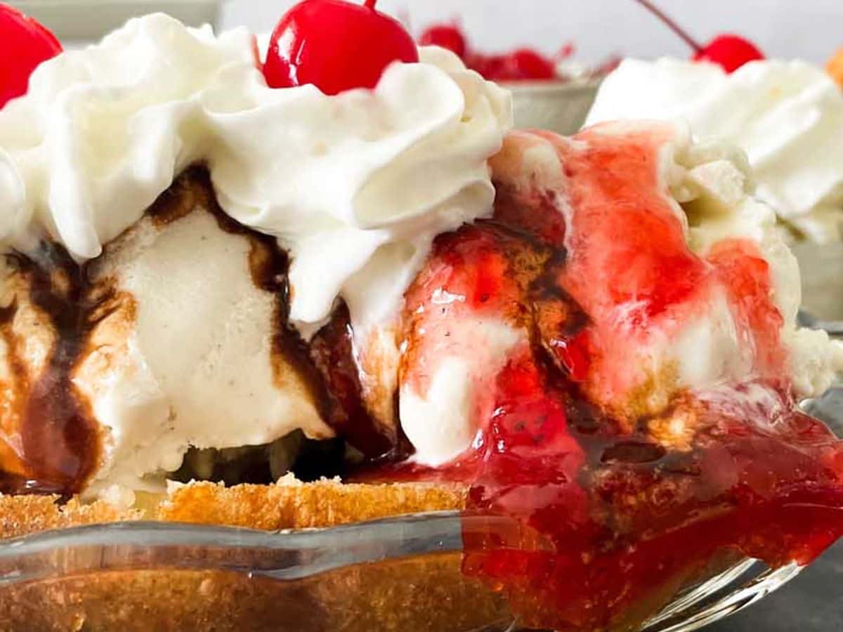 side view of deep fried banana split with ice cream, whipped cream, and cherries