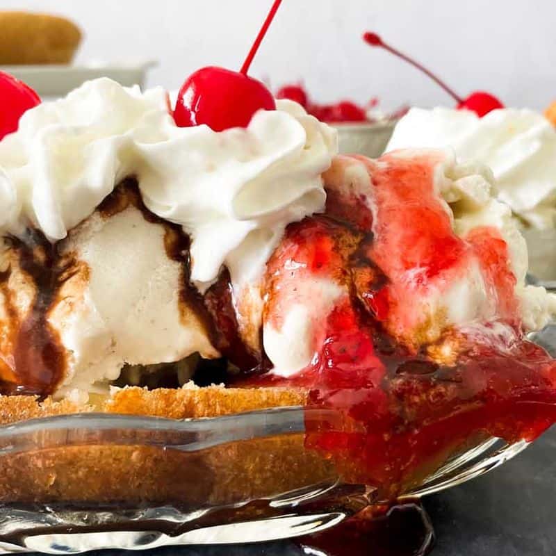 side view of deep fried banana split with ice cream, whipped cream, and cherries