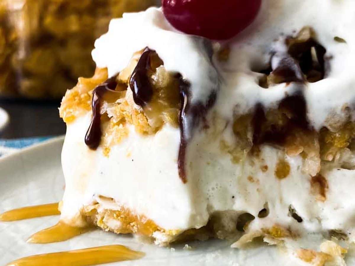 fried ice cream on a plate with chocolate syrup, whipped cream, and a cherry on top