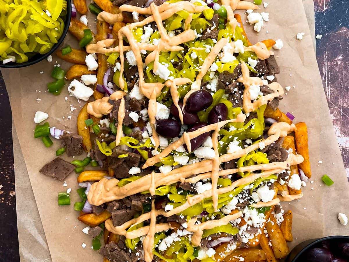 greek street cart fries with gyro doner meat, peppers, onions, olives, pepperoncinis, and aioli sauce
