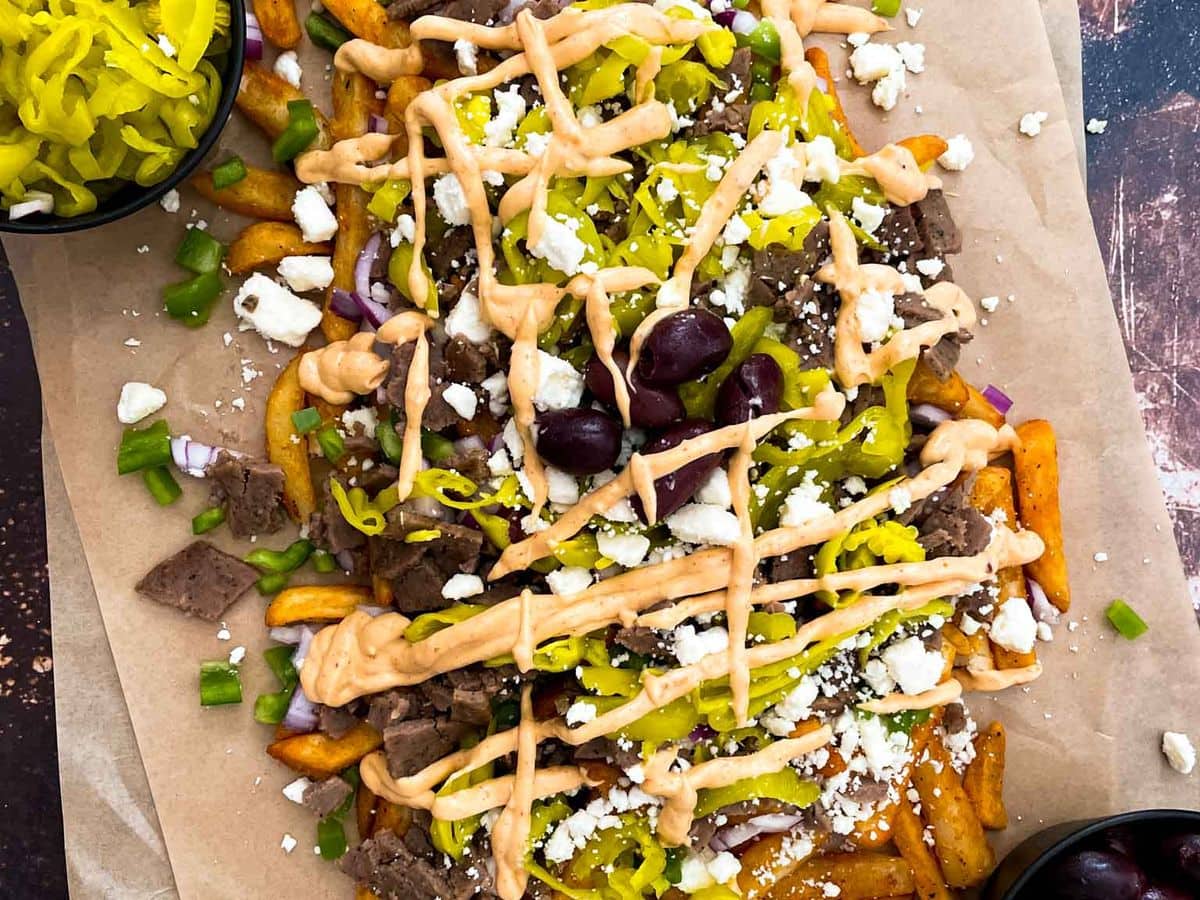 greek street cart fries with gyro doner meat, peppers, onions, olives, pepperoncinis, and aioli sauce