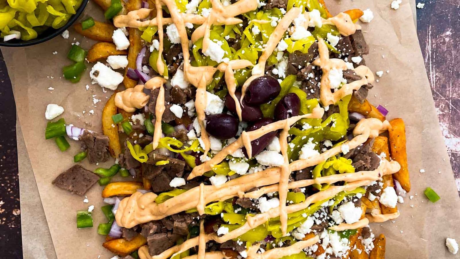 greek street cart fries with gyro doner meat, peppers, onions, olives, pepperoncinis, and aioli sauce