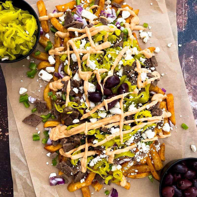 greek street cart fries with gyro doner meat, peppers, onions, olives, pepperoncinis, and aioli sauce