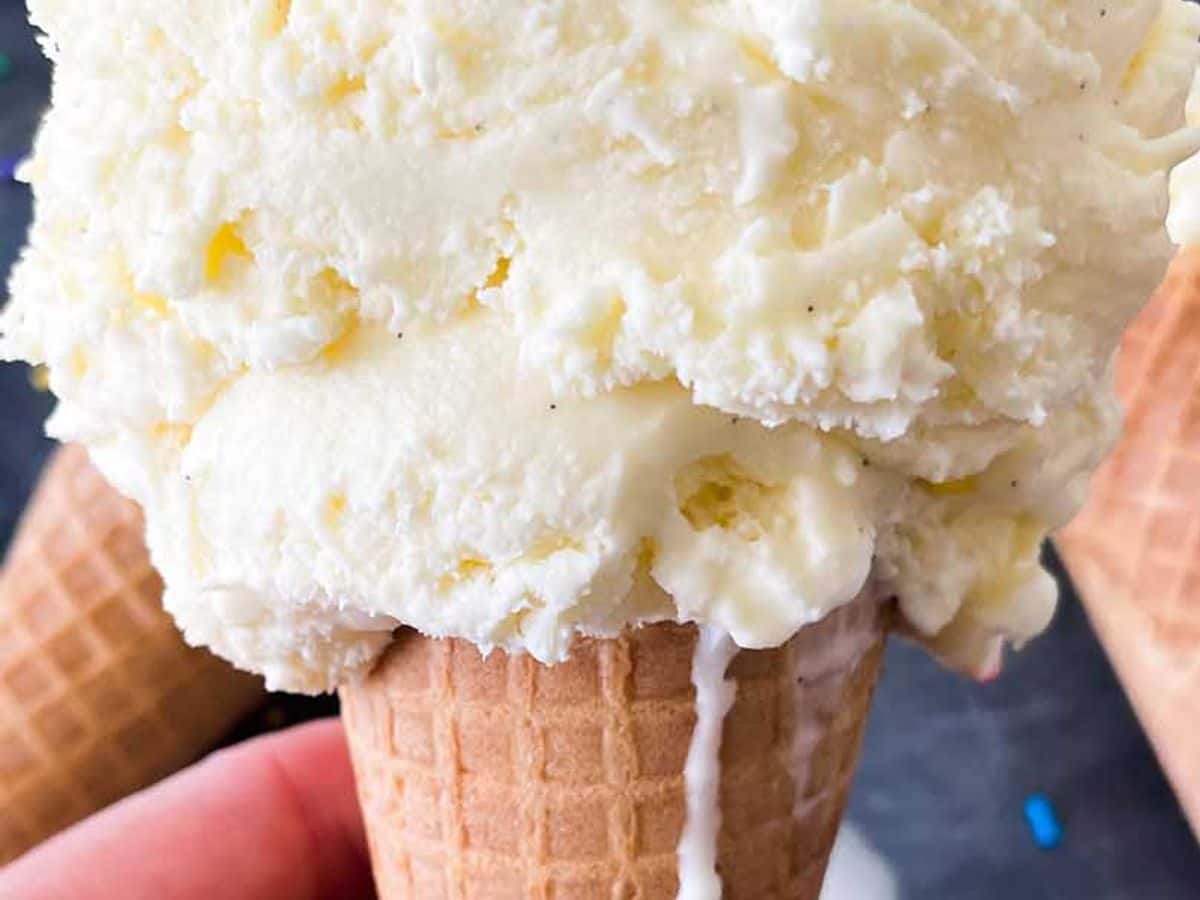 scoop of homemade custard on an ice cream cone being held