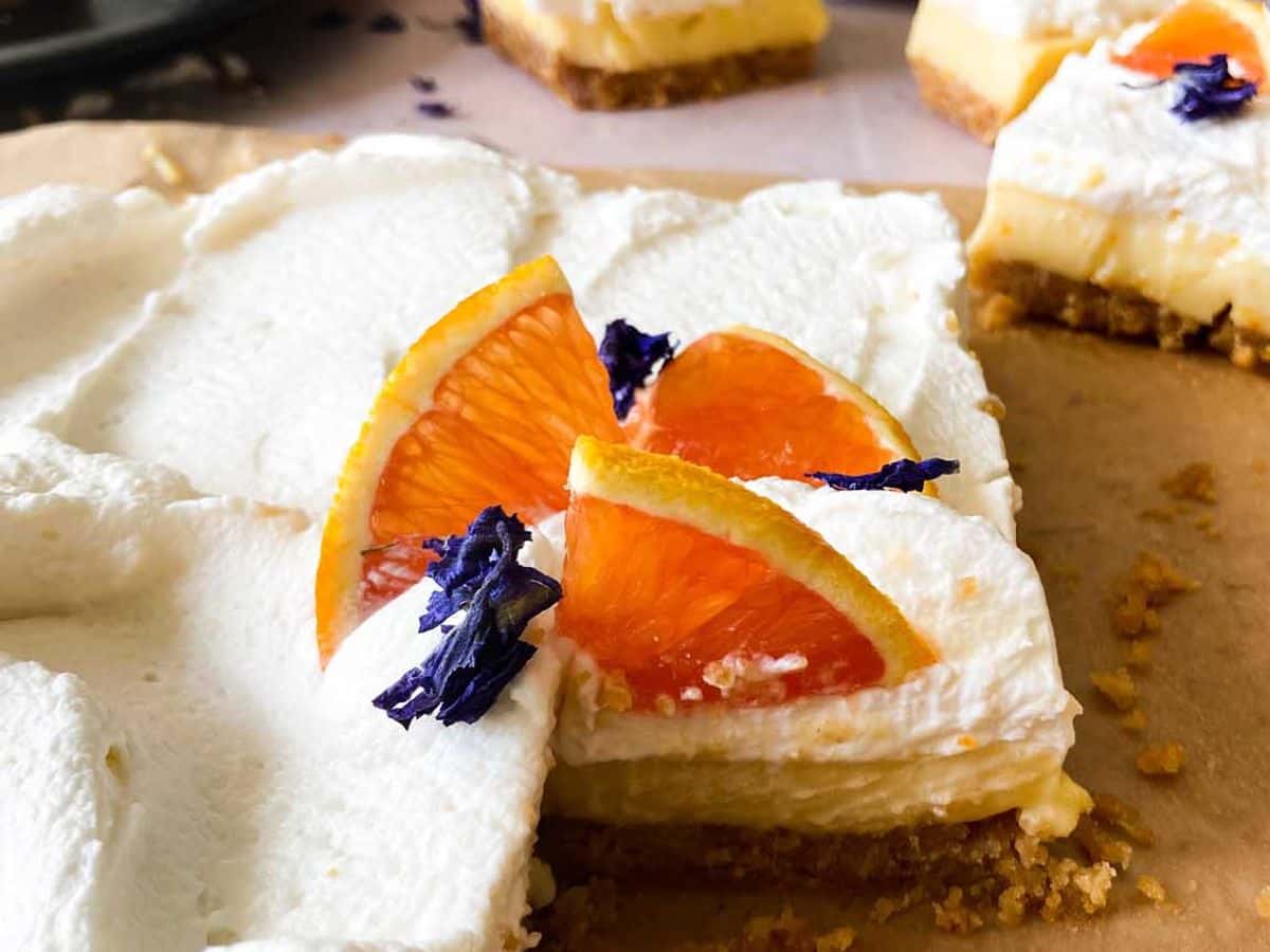 orange bars with honey whipped cream cut and served on plates