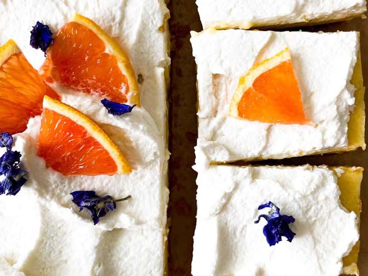 orange bars with honey whipped cream, topped with orange slices and cut into pieces