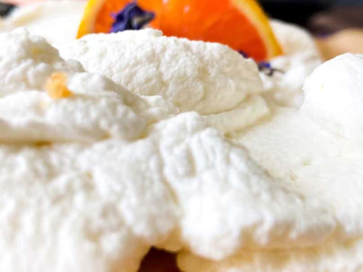 orange bars from the side showing orange filling and honey whipped cream topping