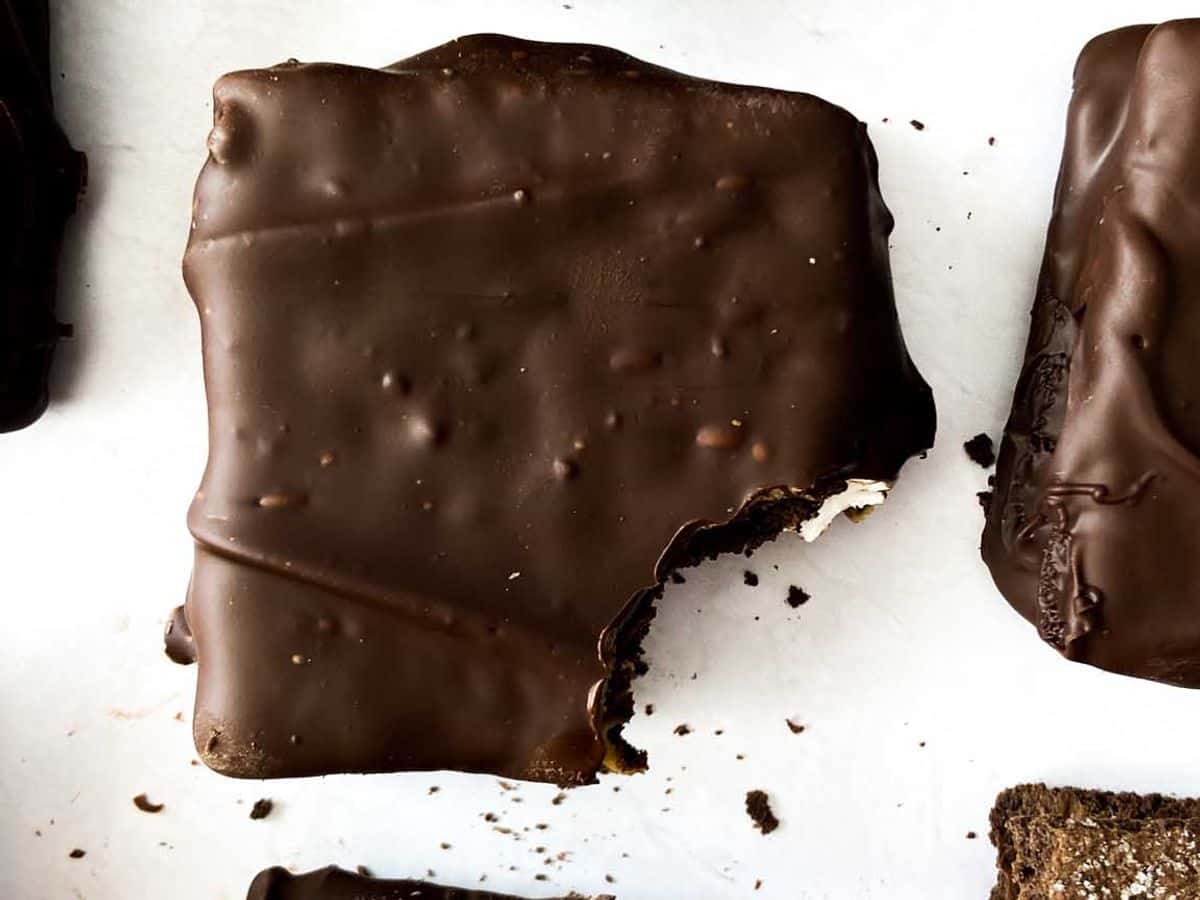 peanut butter smores bars covered in chocolate coating with a bite taken out of it
