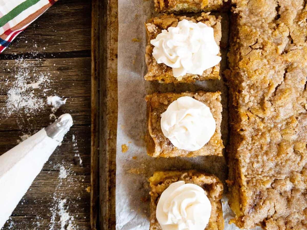pumpkin pie cake with three pieces cut and topped with whipped cream