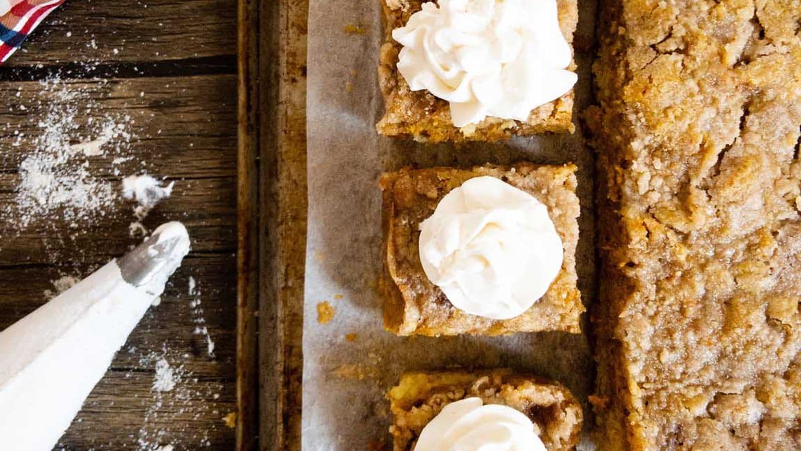pumpkin pie cake with three pieces cut and topped with whipped cream