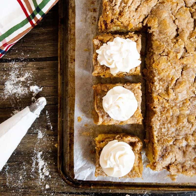 pumpkin pie cake with three pieces cut and topped with whipped cream