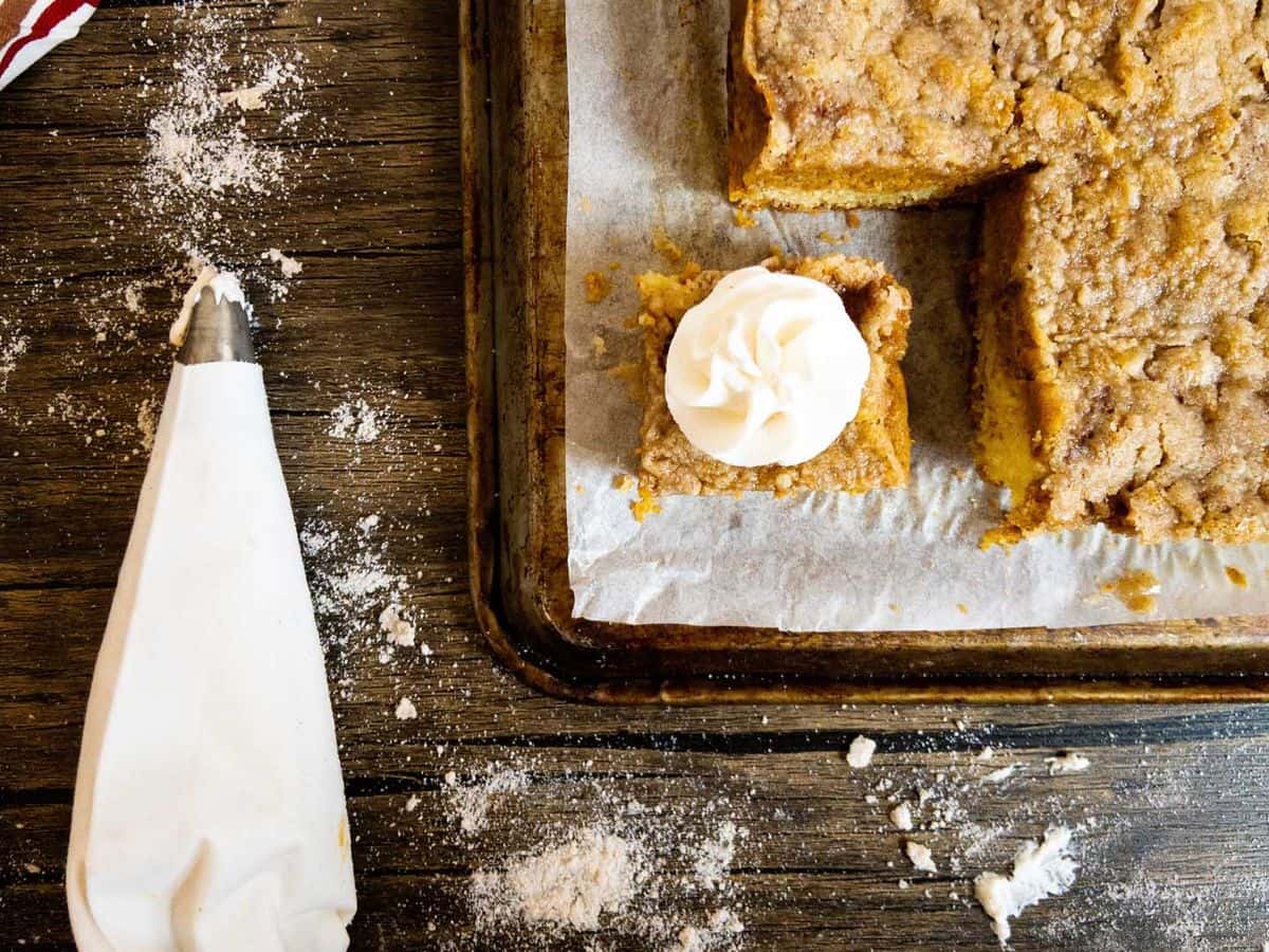 pumpkin pie cake with one piece cut and topped with whipped cream