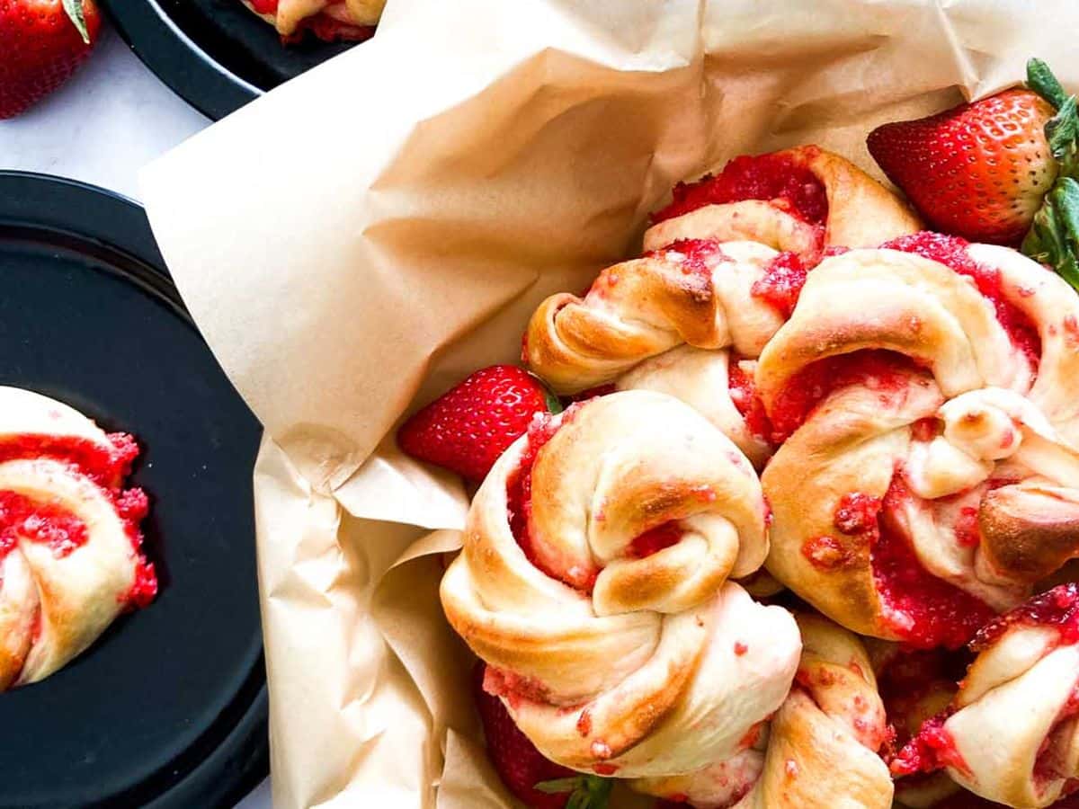 strawberry knots bread rolls in a bowl with strawberries