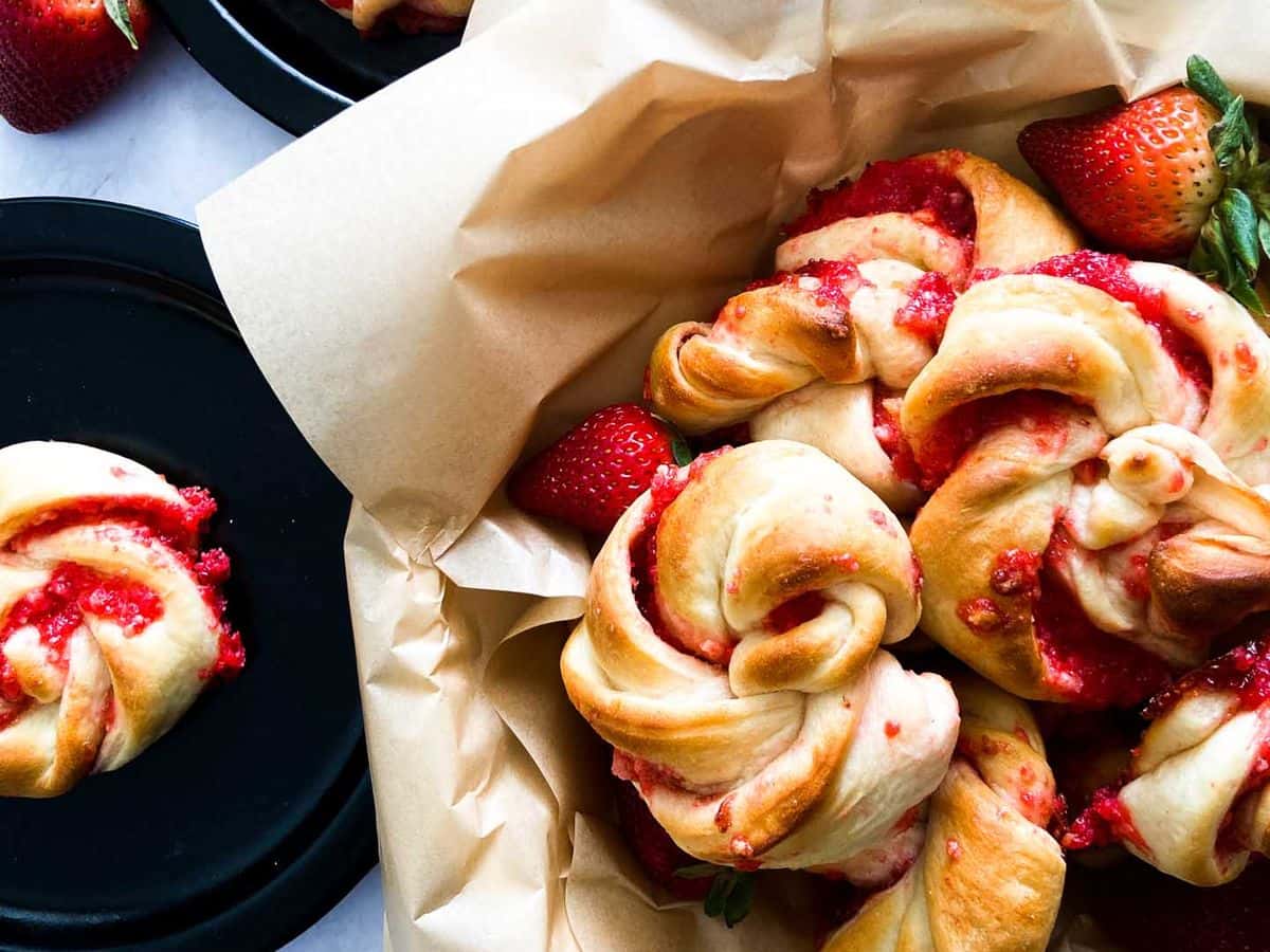 strawberry knots bread rolls in a bowl with strawberries close up