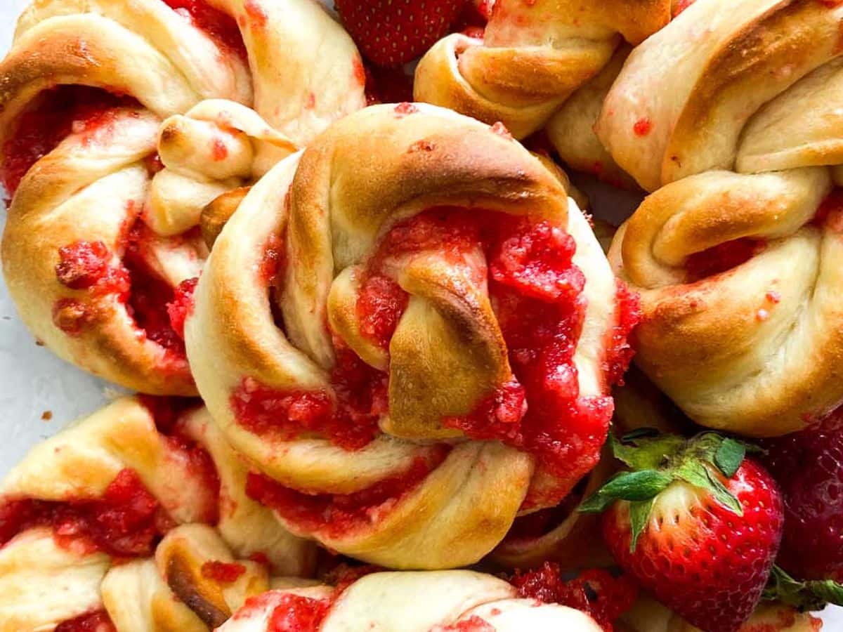 strawberry knots bread rolls piled up with fresh strawberries