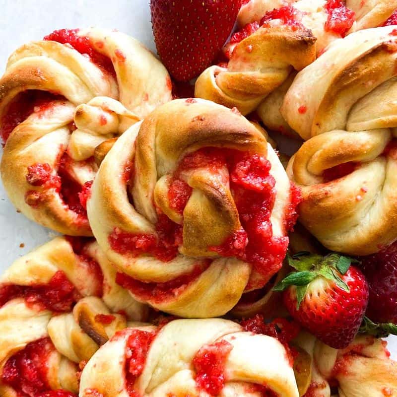 strawberry knots bread rolls piled up with fresh strawberries