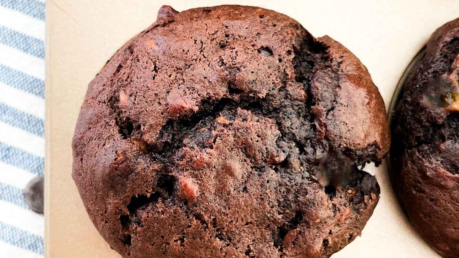 close up shot of the best chocolate chocolate chip banana muffins inside a gold muffin tin