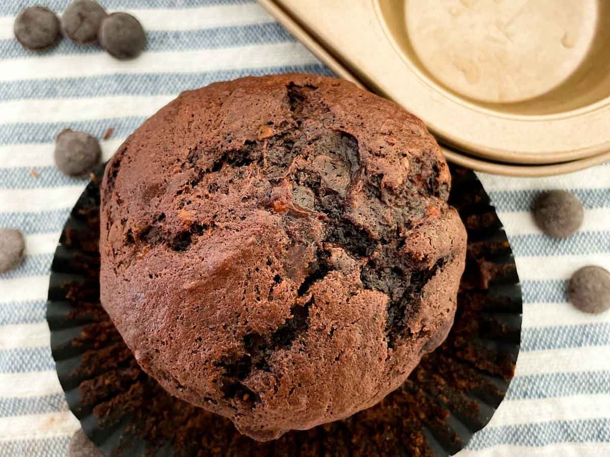close up shot of the best chocolate chocolate chip banana muffins inside a gold muffin liner
